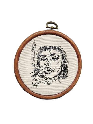 haftowana ozdoba na ścianę przedstawiająca kobietę z papierosem
