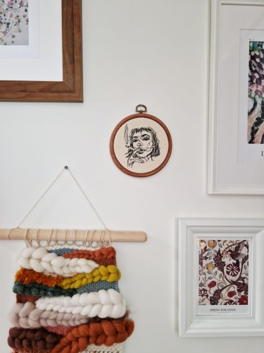 haftowana ozdoba na ścianę przedstawiająca kobietę z papierosem