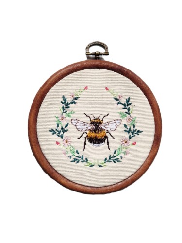 haftowany trzmiel otoczony zielonymi gałązkami i kwiatami